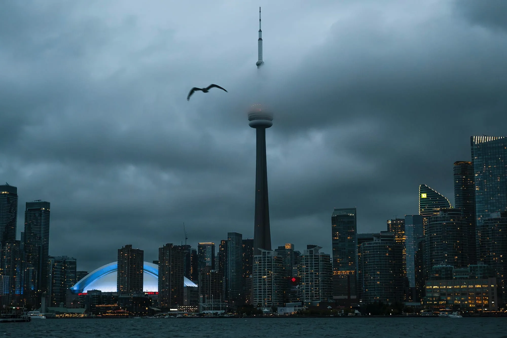 Toronto skyline and the CN Tower beneath a dark, cloudy sky